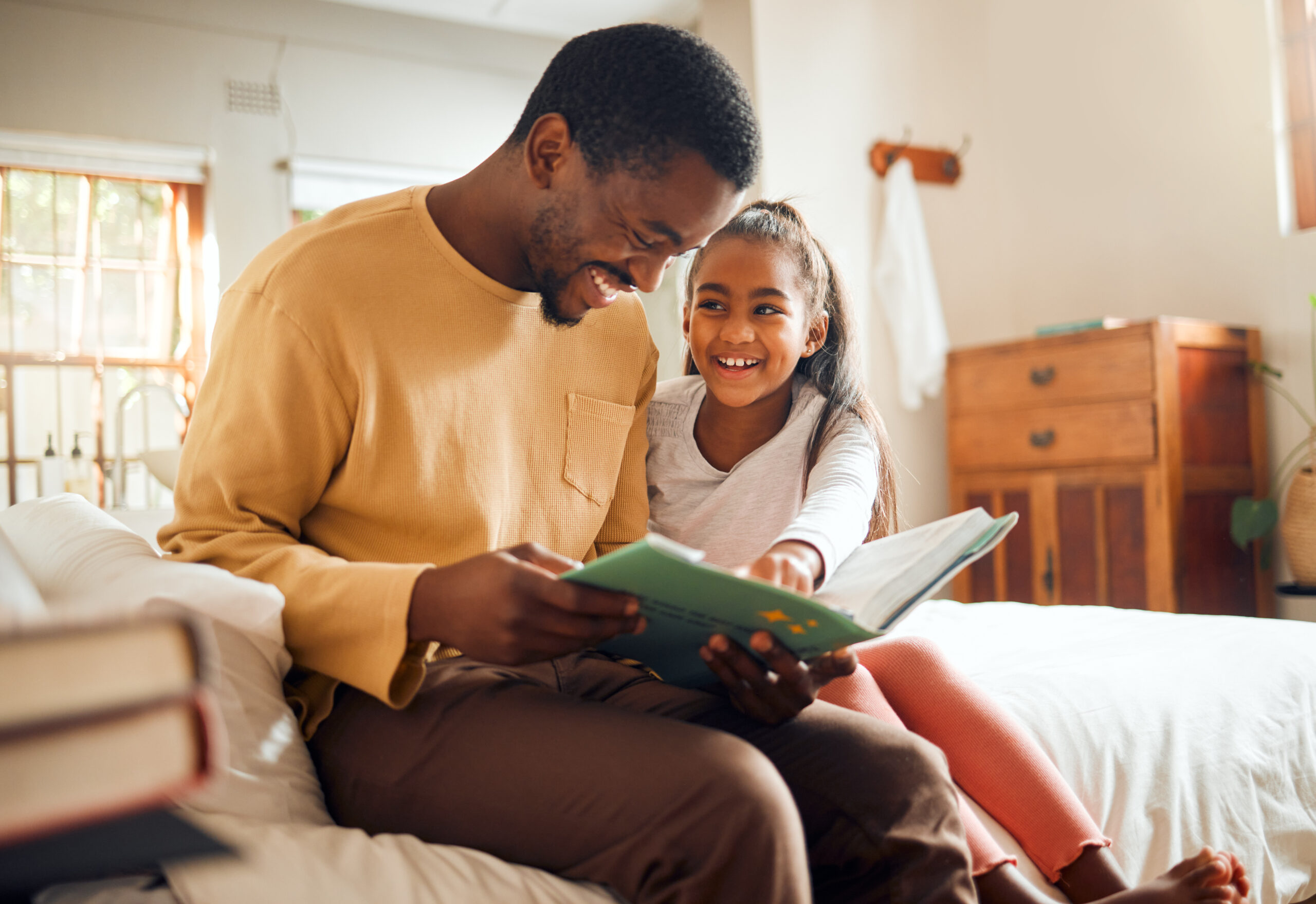 Black family, father reading to child and bonding love, storytelling and language learning in bedroom. Happy people, dad and girl kid with book for creative knowledge, education and home teaching.